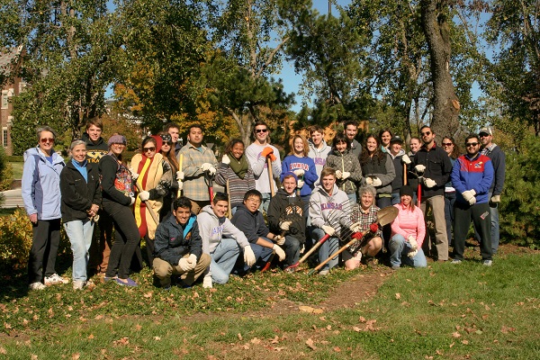 Group of about 30 people with shovels facing the camera.